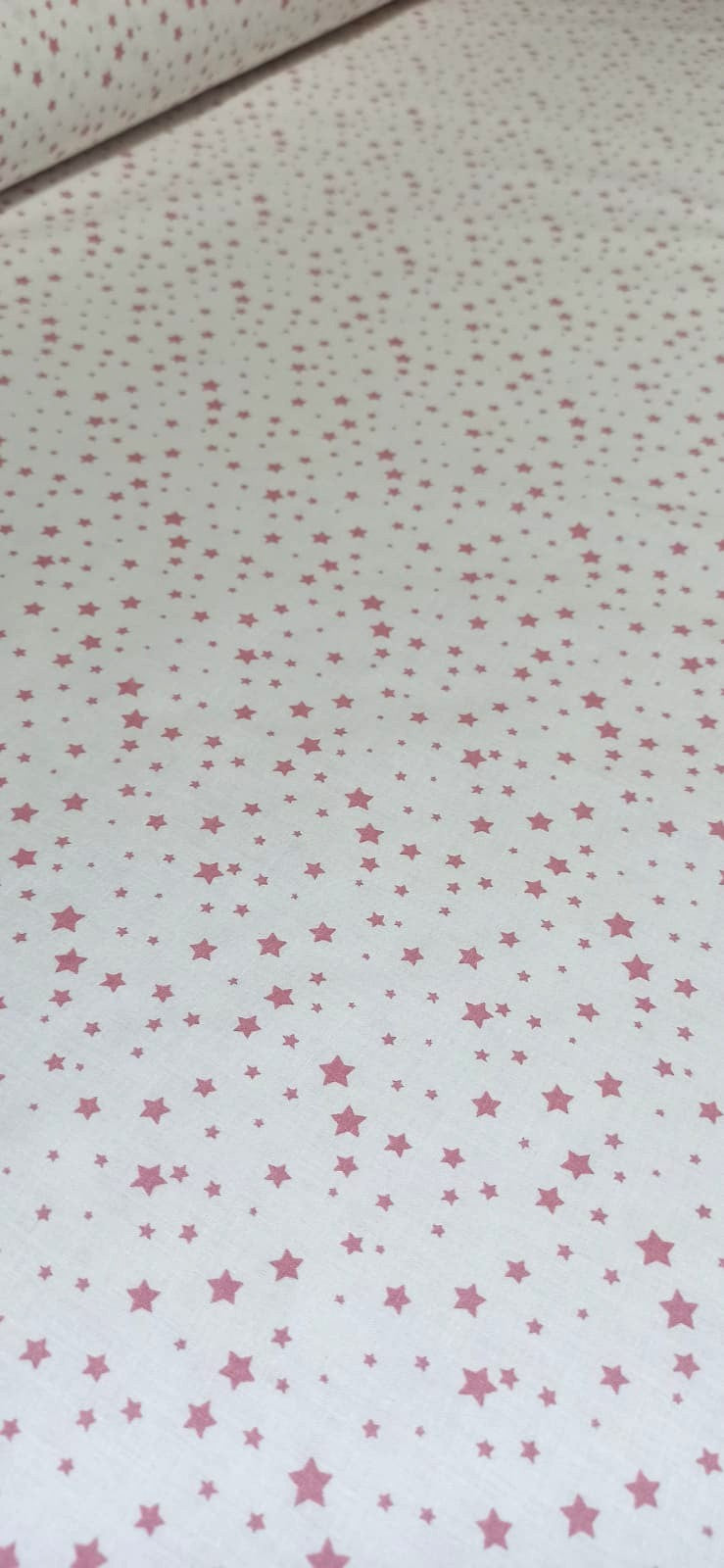 Algodón de estrellas rosa bebé doblado mostrando el estampado completo