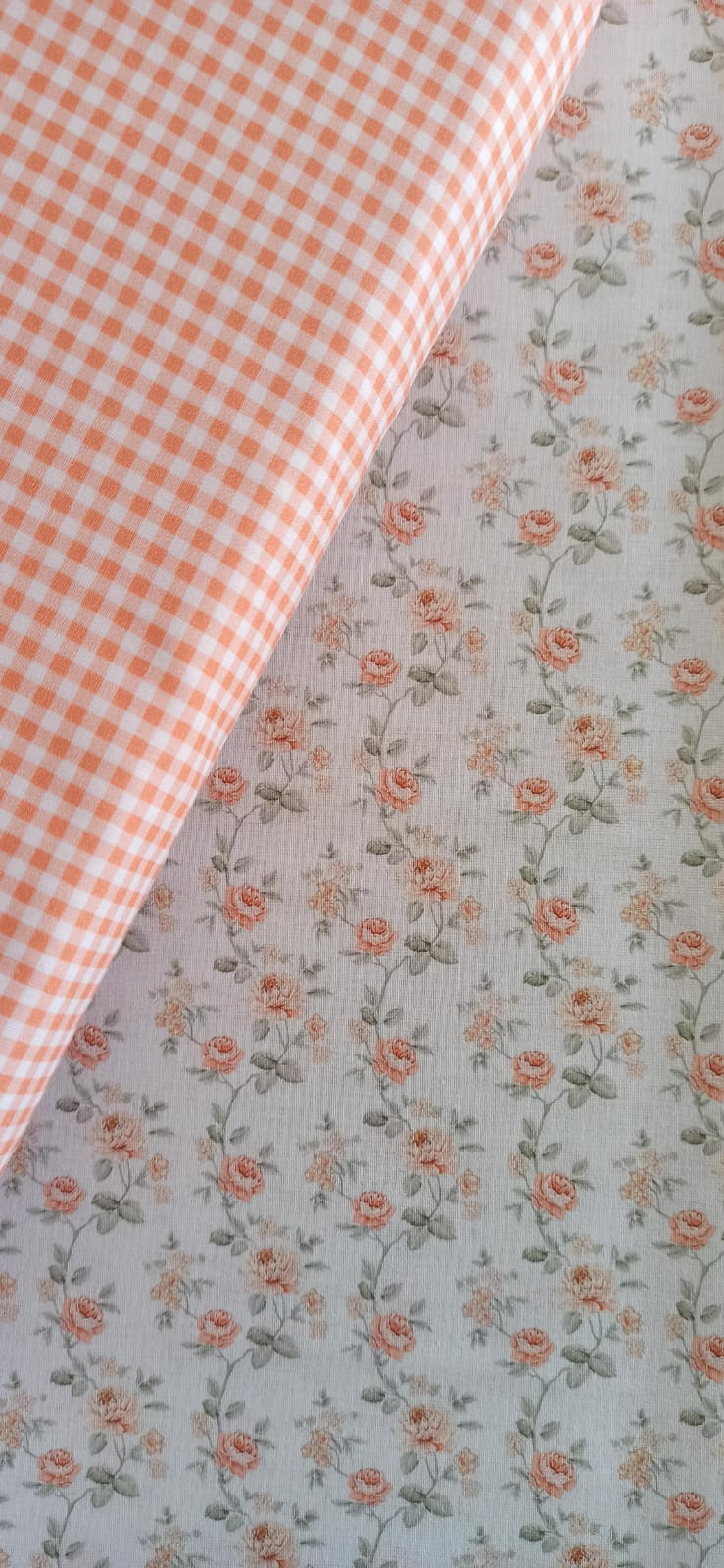 Tela de pequeñas rosas melocotón y hojas sobre fondo blanco