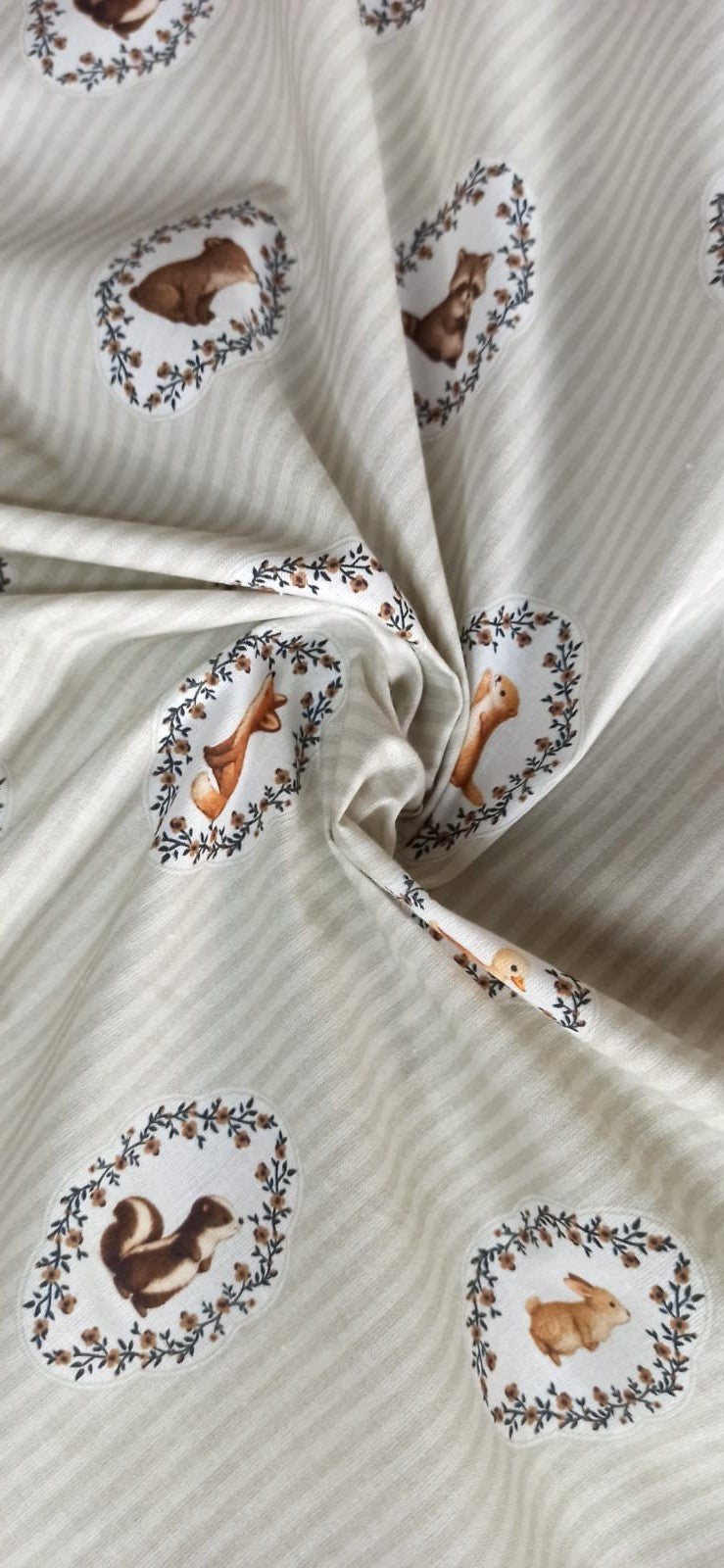Detalle del estampado de animales en marcos vegetales sobre algodón de rayas