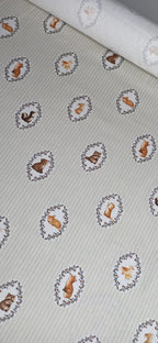 Estampado infantil de animales enmarcados con guirnaldas vegetales en tela de algodón