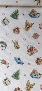 Detalle de zorro, conejo y erizo entre regalos y abetos en el estampado navideño de algodón.
