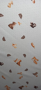 Tela de algodón con animales y motivos vegetales sobre fondo claro de pequeños puntos