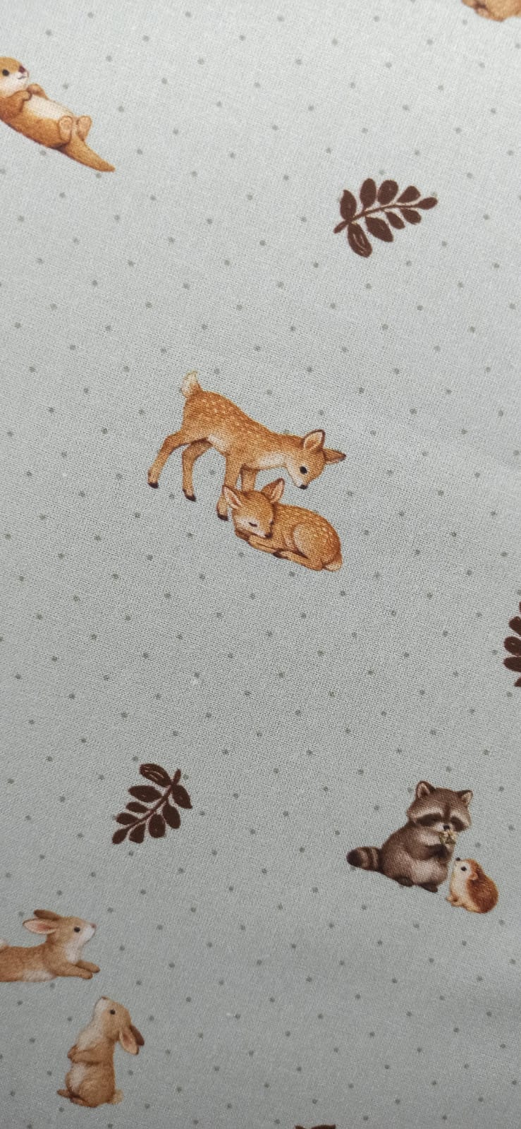 Detalle de animalitos y hojas en tela de algodón con fondo de puntitos