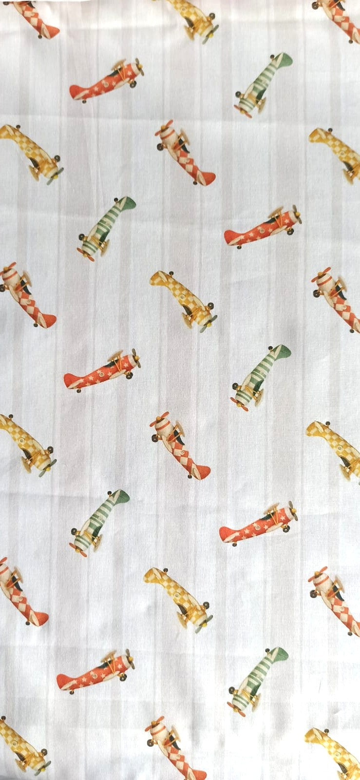 Tela de algodón con aviones vintage rojos, verdes y mostaza sobre fondo de rayas beige