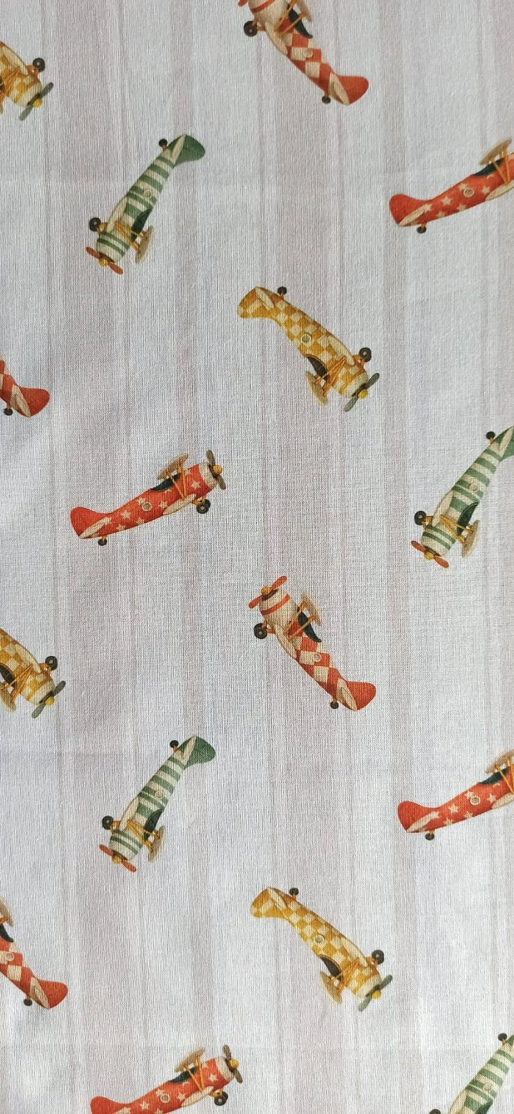 Tela de algodón con aviones vintage rojos, verdes y mostaza sobre fondo de rayas beige