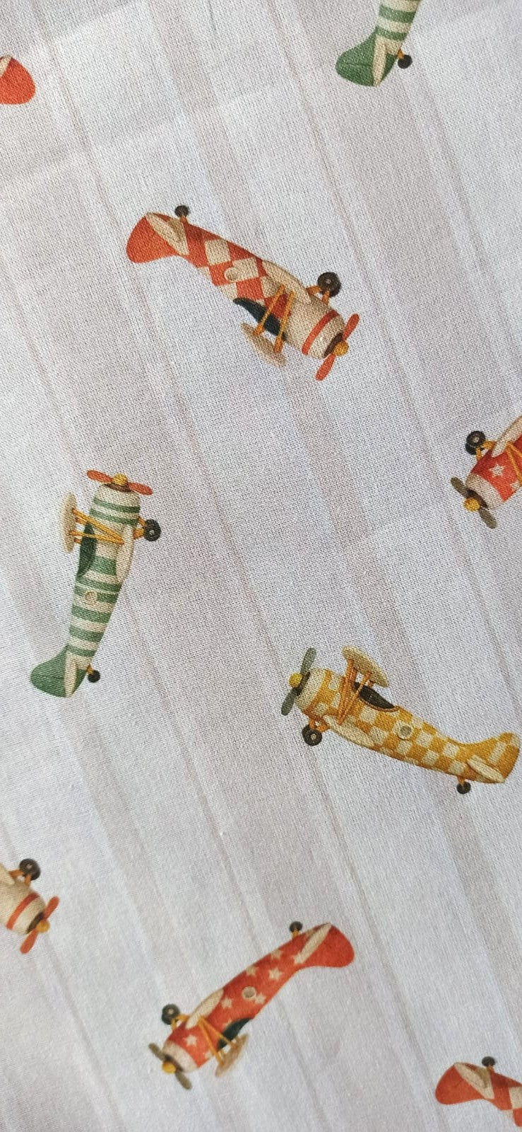 Tela de algodón con aviones vintage rojos, verdes y mostaza sobre fondo de rayas beige