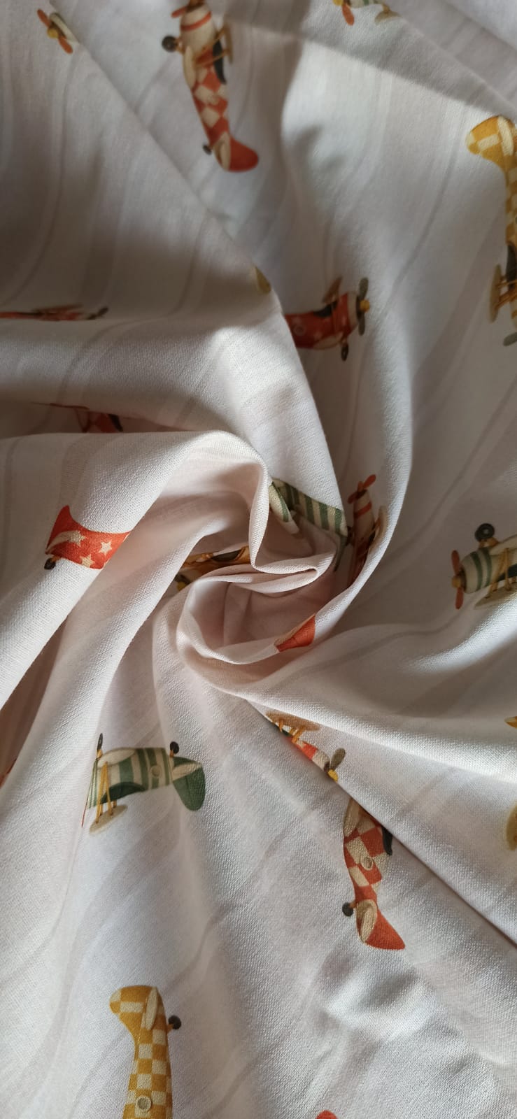 Tela de algodón con aviones vintage rojos, verdes y mostaza sobre fondo de rayas beige