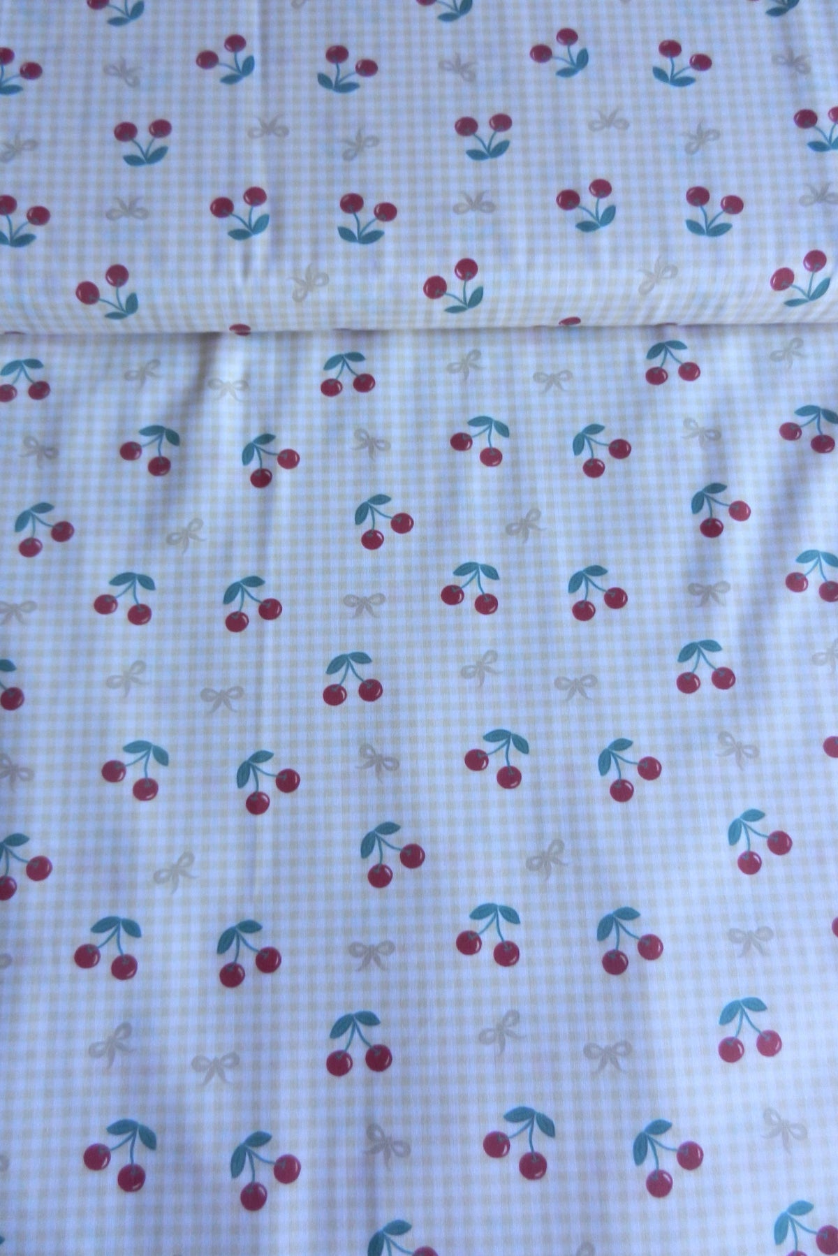 Estampado de cerezas y lazos sobre vichy amarillo