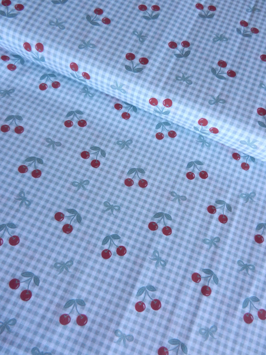 Estampado de cerezas sobre fondo vichy verde