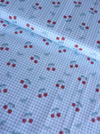 Estampado de cerezas sobre fondo vichy verde