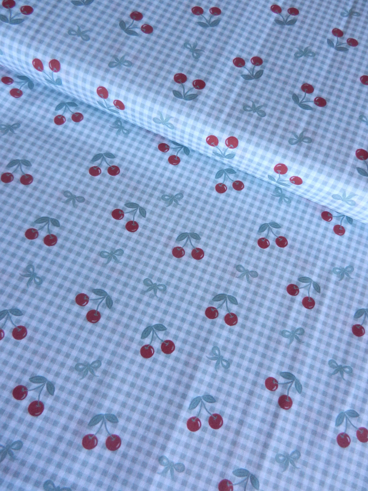 Estampado de cerezas sobre fondo vichy verde