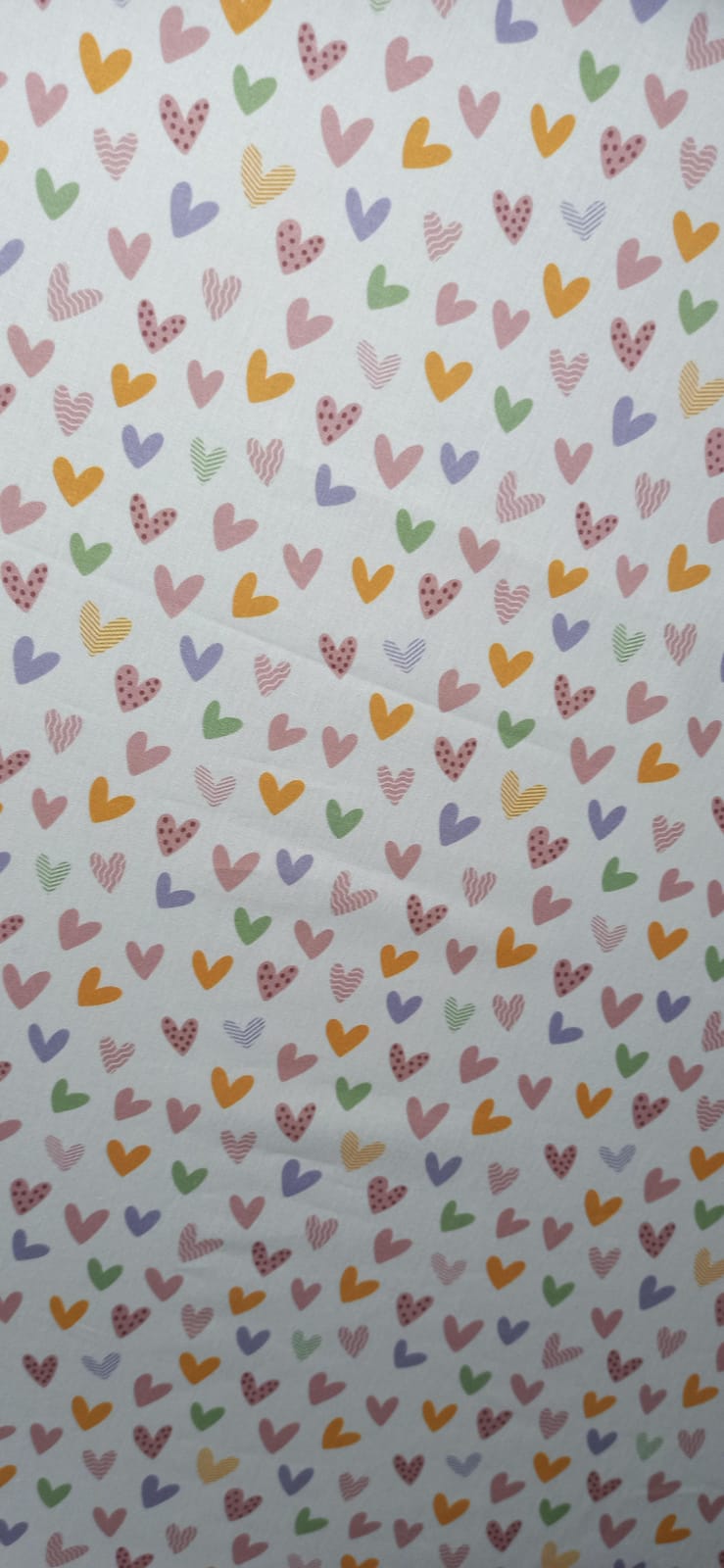 Tela de algodón con corazones rosas, lilas, verdes y mostaza sobre fondo claro