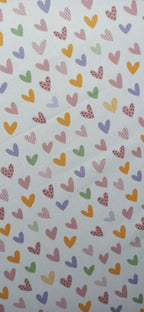 Algodón con pequeños corazones multicolor repartidos sobre fondo claro