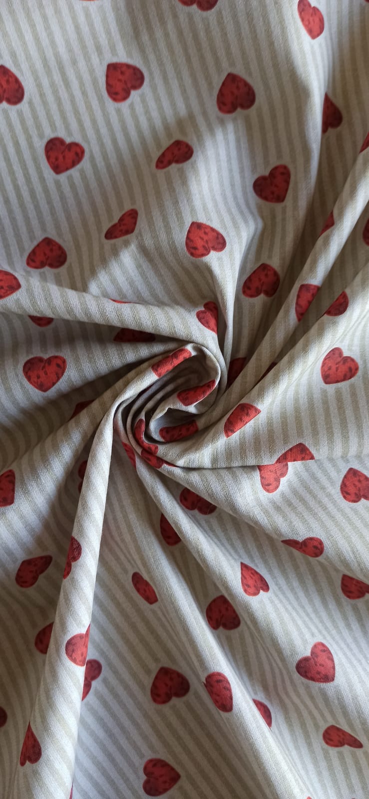 Tela de algodón con corazones sobre fondo beige a rayas