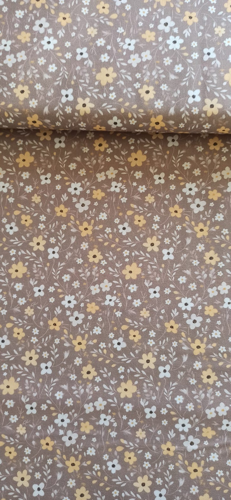 Tela floral marrón topo extendida con un pliegue