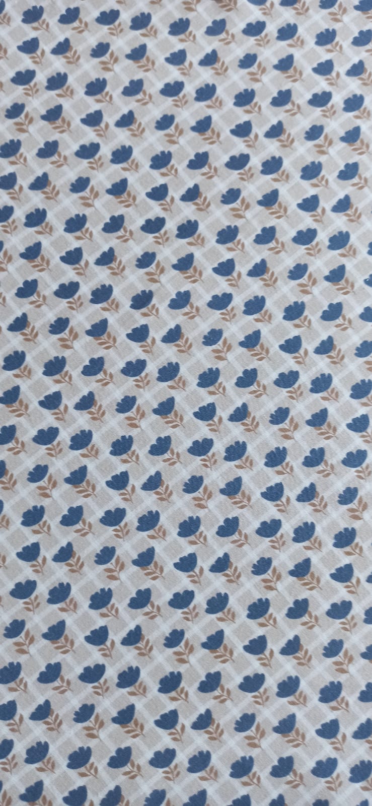 Vista del tejido de flores azules sobre cuadros beige