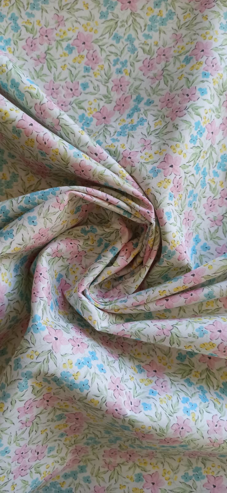 Tela de flores rosas y azules con detalles amarillos y hojas verdes