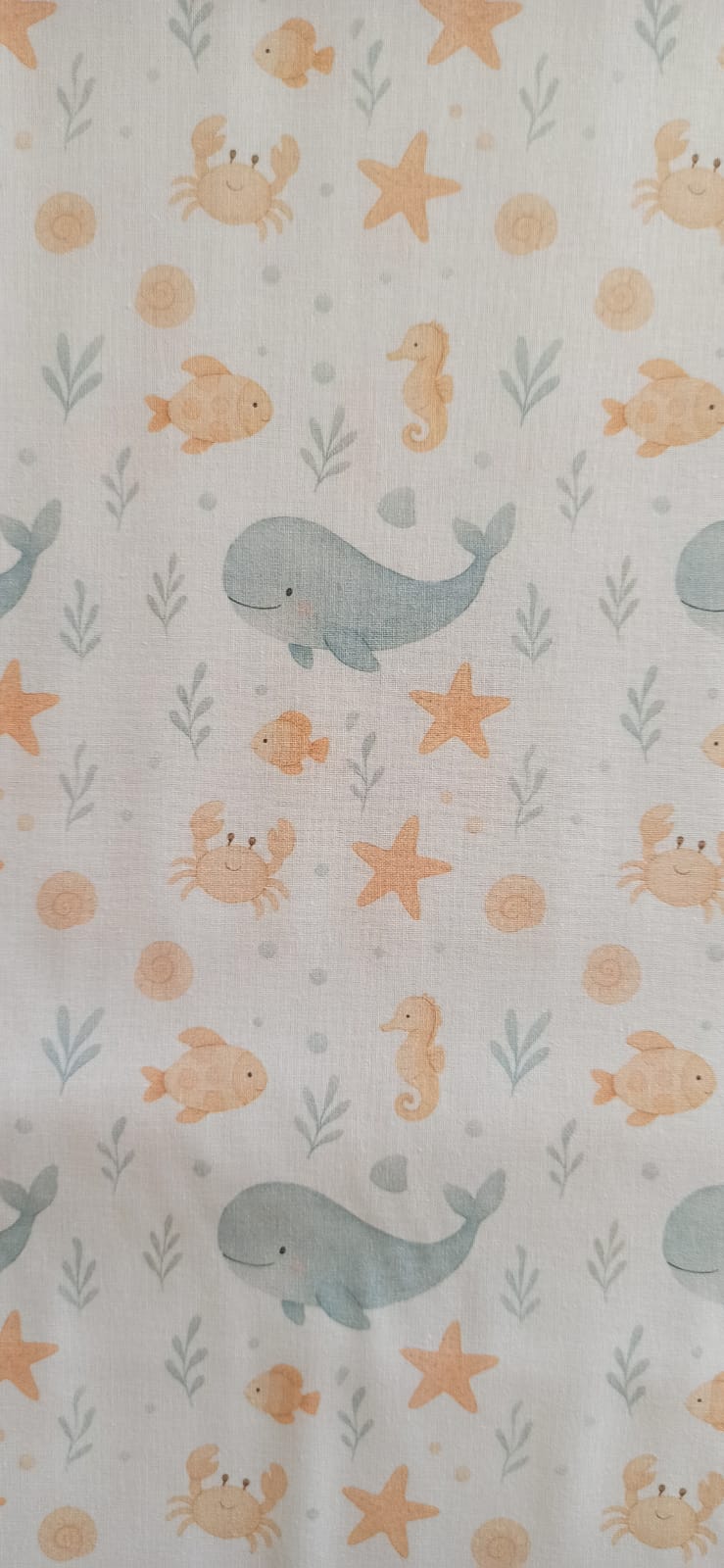 Detalle del estampado infantil de ballenas y animales marinos