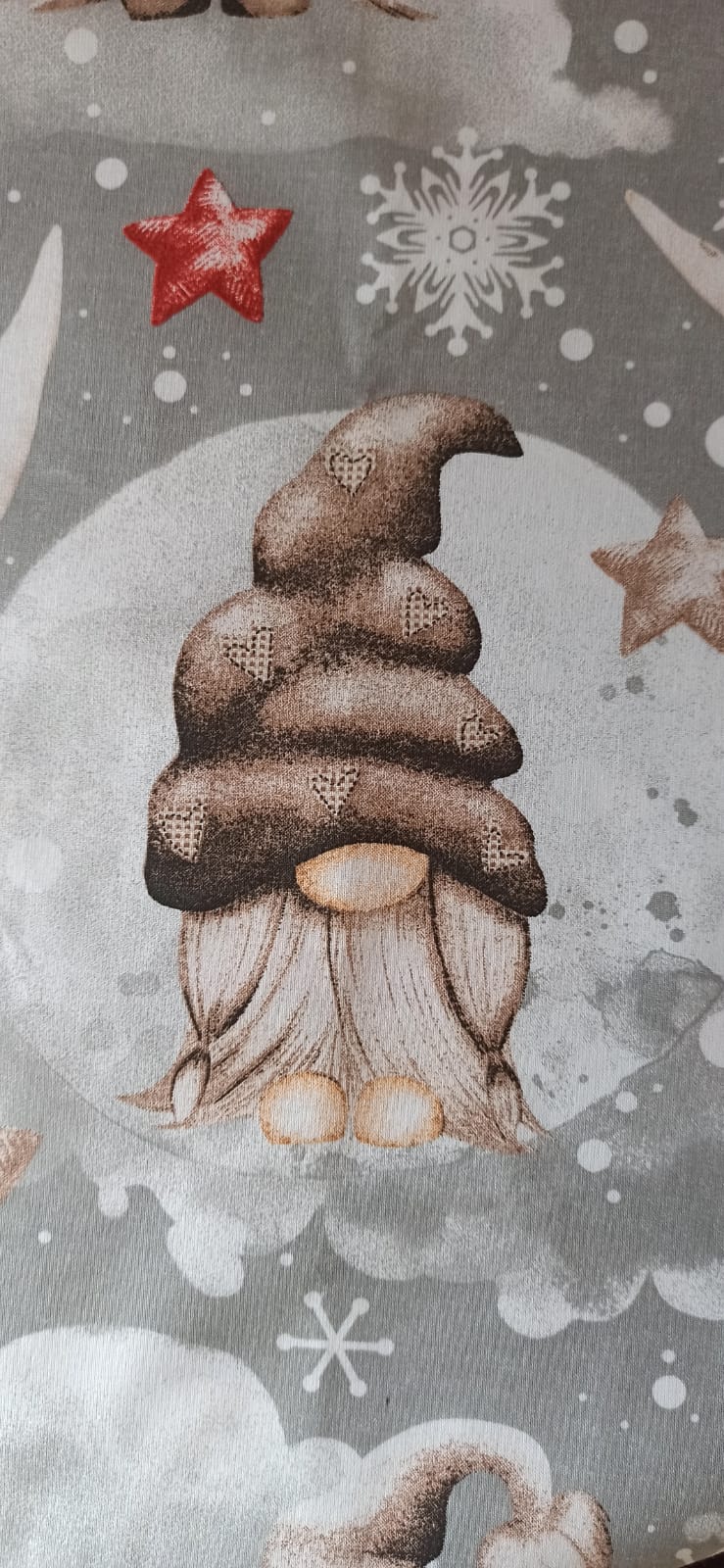 Detalle de gnomo con gorro marrón y estrellas en tela navideña gris