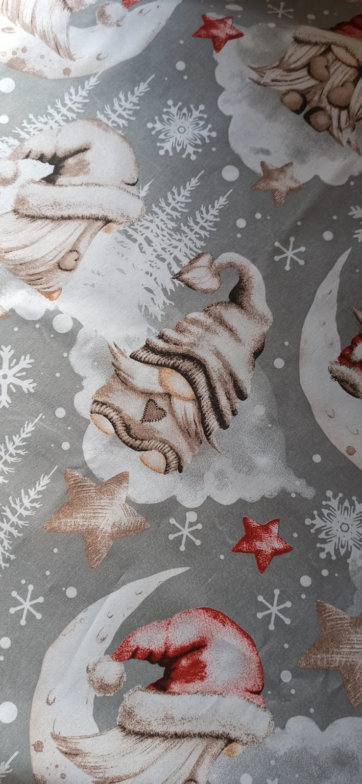 Detalle del estampado de gnomos y copos de nieve sobre fondo gris