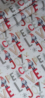 Detalle del estampado navideño de gnomos y letras en rojo, gris y beige