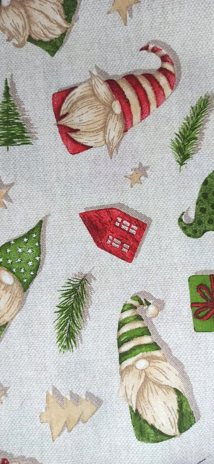 Detalle de loneta navideña con gnomos de gorros de rayas y casita roja