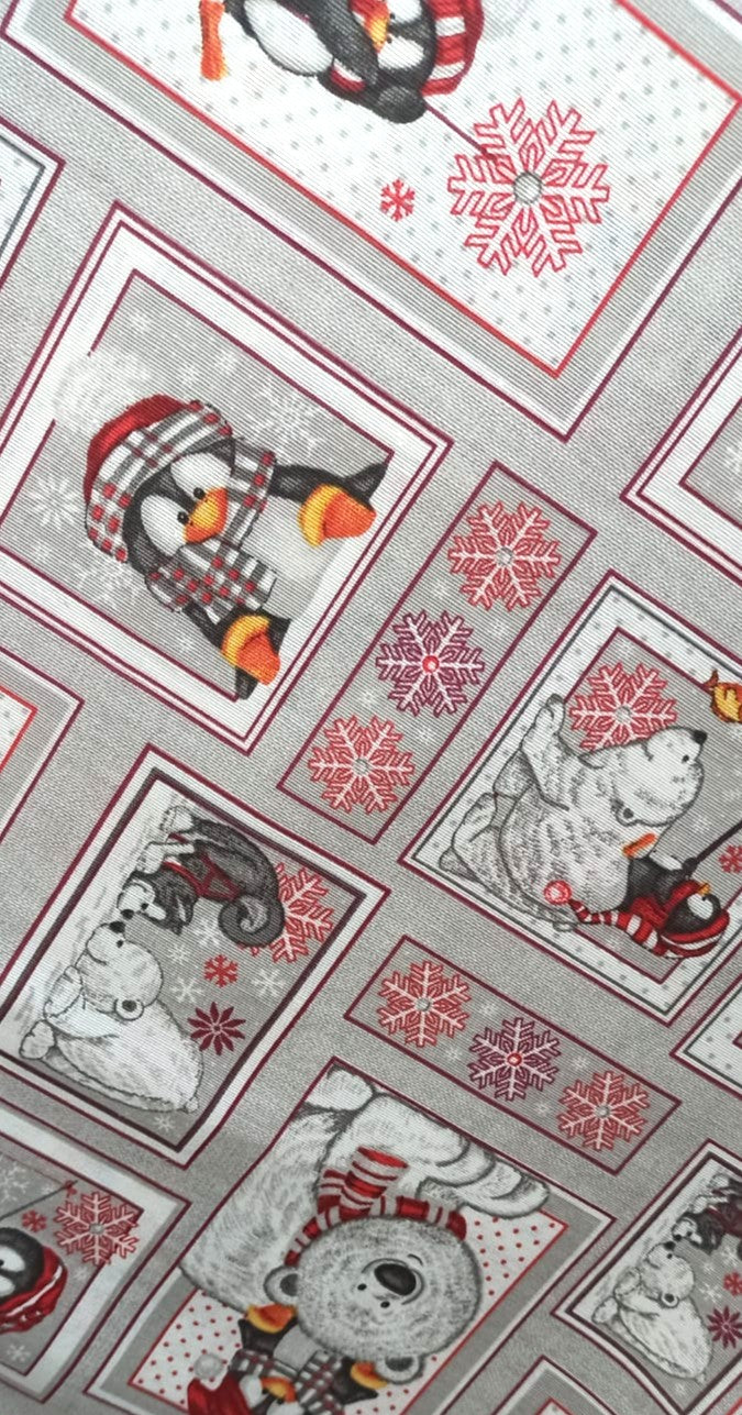 Vista del estampado de pingüinos y osos polares con detalles rojos sobre loneta gris