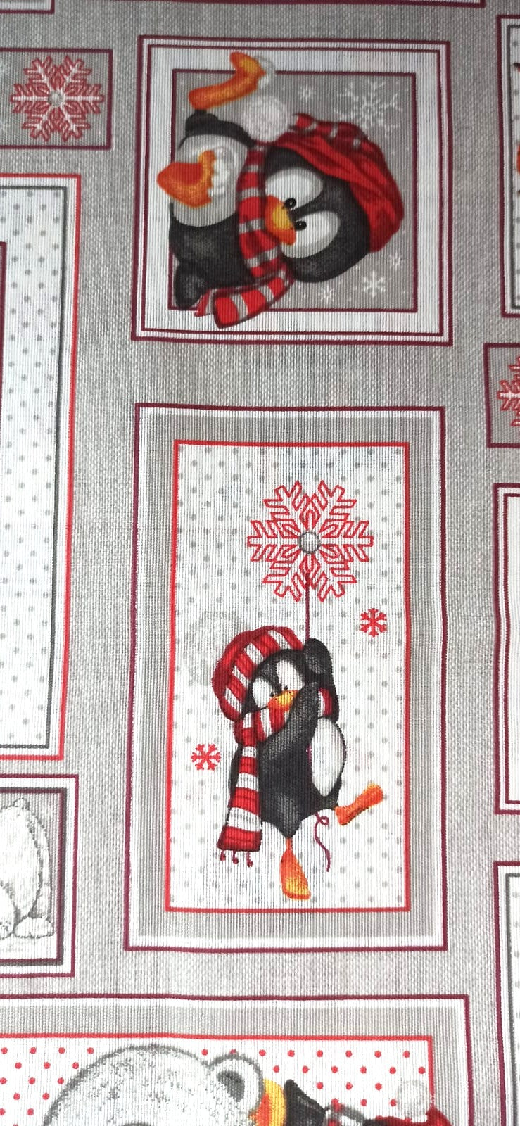 Detalle de pingüinos con gorros y bufandas en recuadros sobre fondo gris