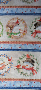 Detalle de muñecos de nieve con bufandas y pajaritos rojos entre cenefas azules