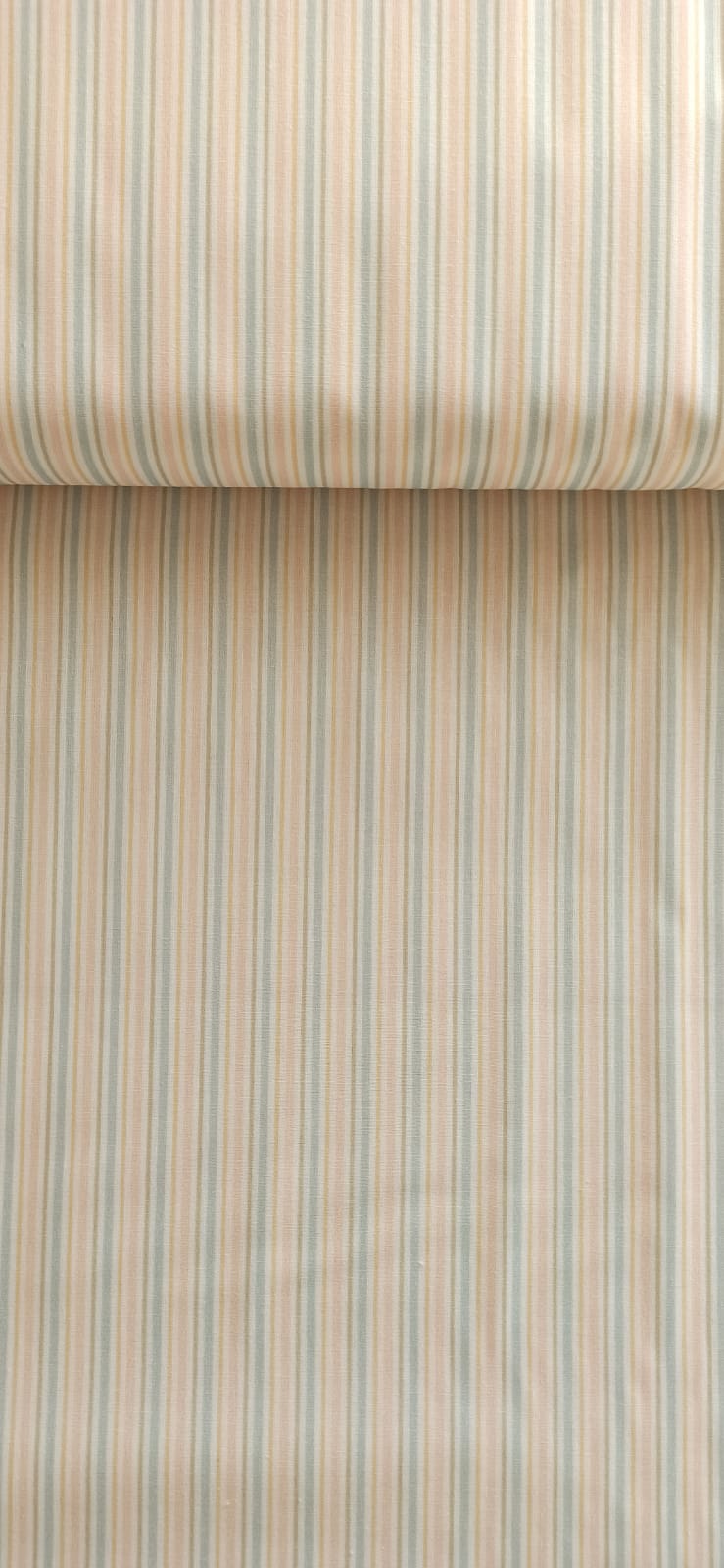 Detalle de rayas de varios anchos en azul suave, arena y rosa pálido