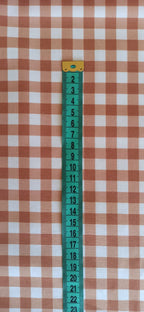 Cuadros de vichy marrón de 1 cm junto a cinta métrica