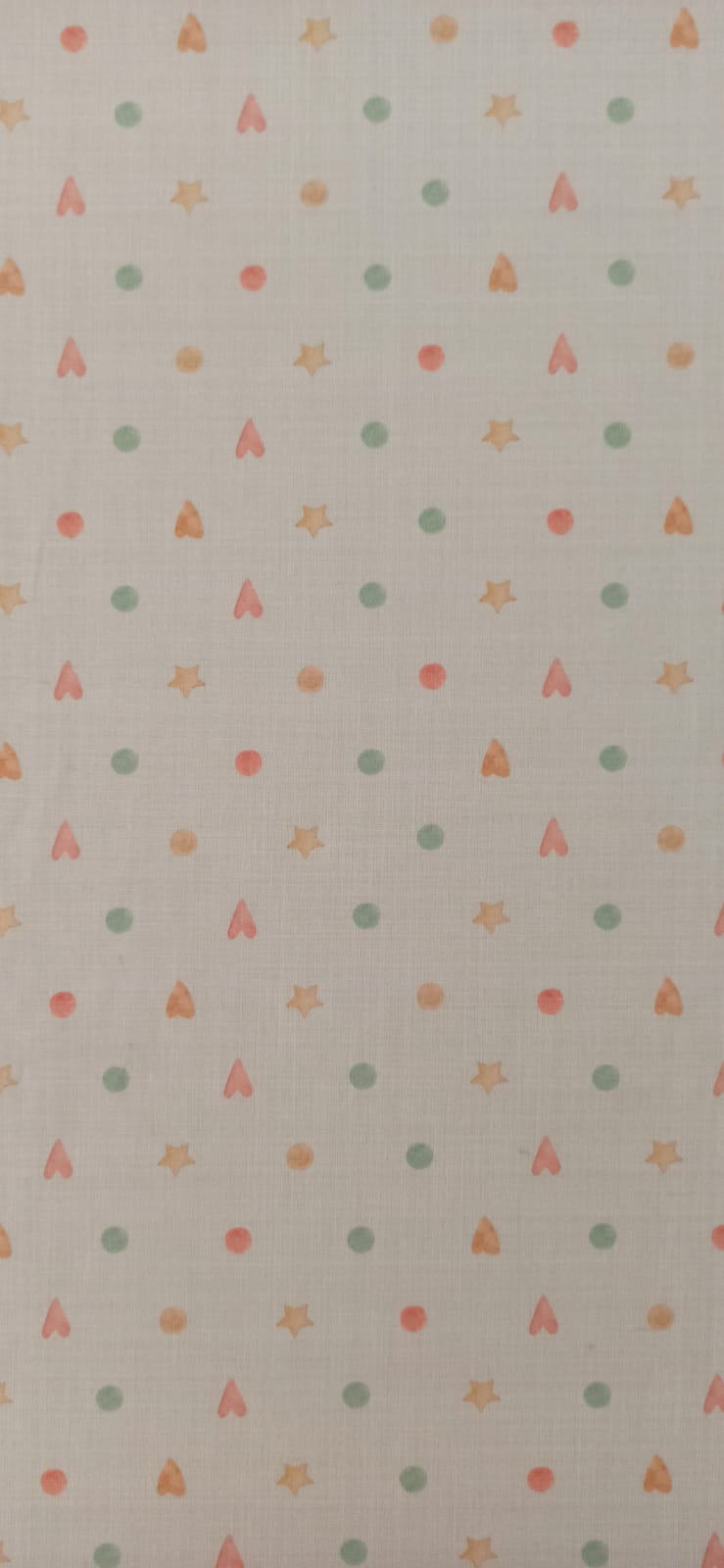 Algodón infantil con corazones, estrellas y círculos en tonos pastel sobre fondo crema