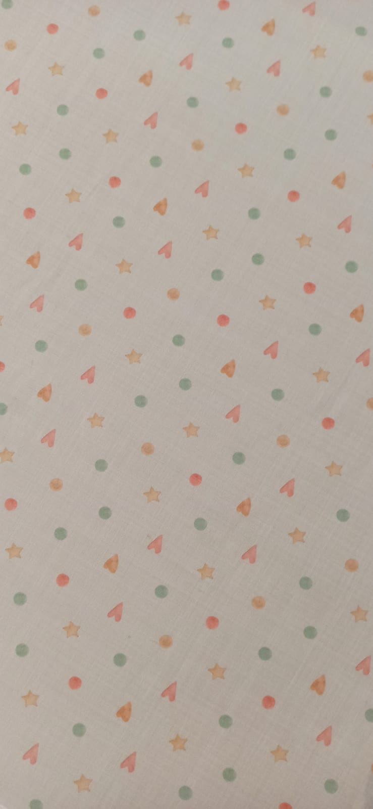 Algodón infantil con corazones, estrellas y círculos en tonos pastel sobre fondo crema
