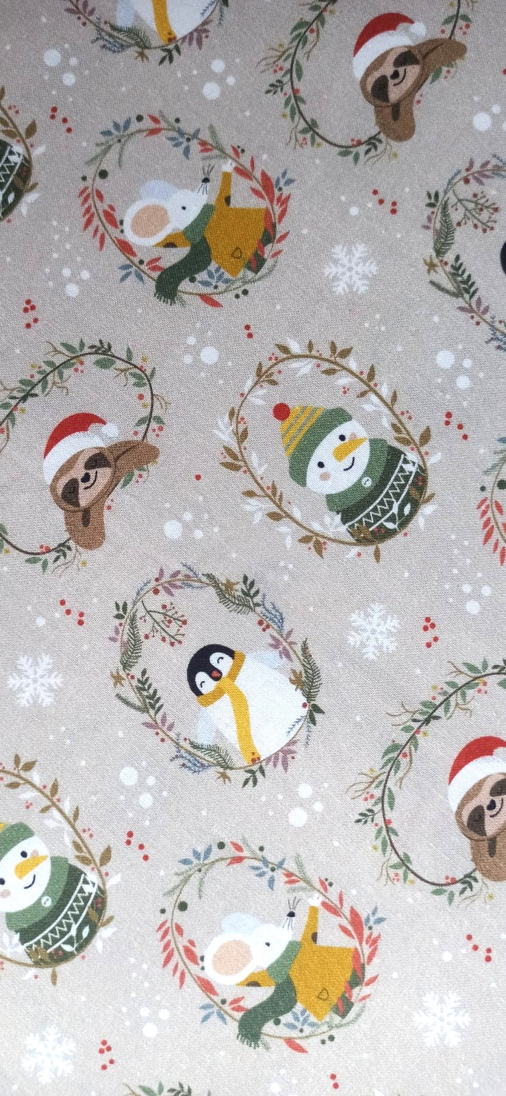 Detalle de animalitos navideños y copos blancos sobre fondo beige grisáceo