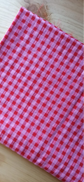 Retal seersucker rosa y rojo doblado sobre una mesa