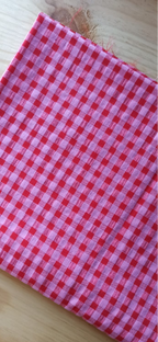 Retal seersucker rosa y rojo doblado sobre una mesa