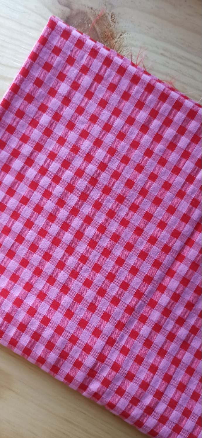 Retal seersucker rosa y rojo doblado sobre una mesa
