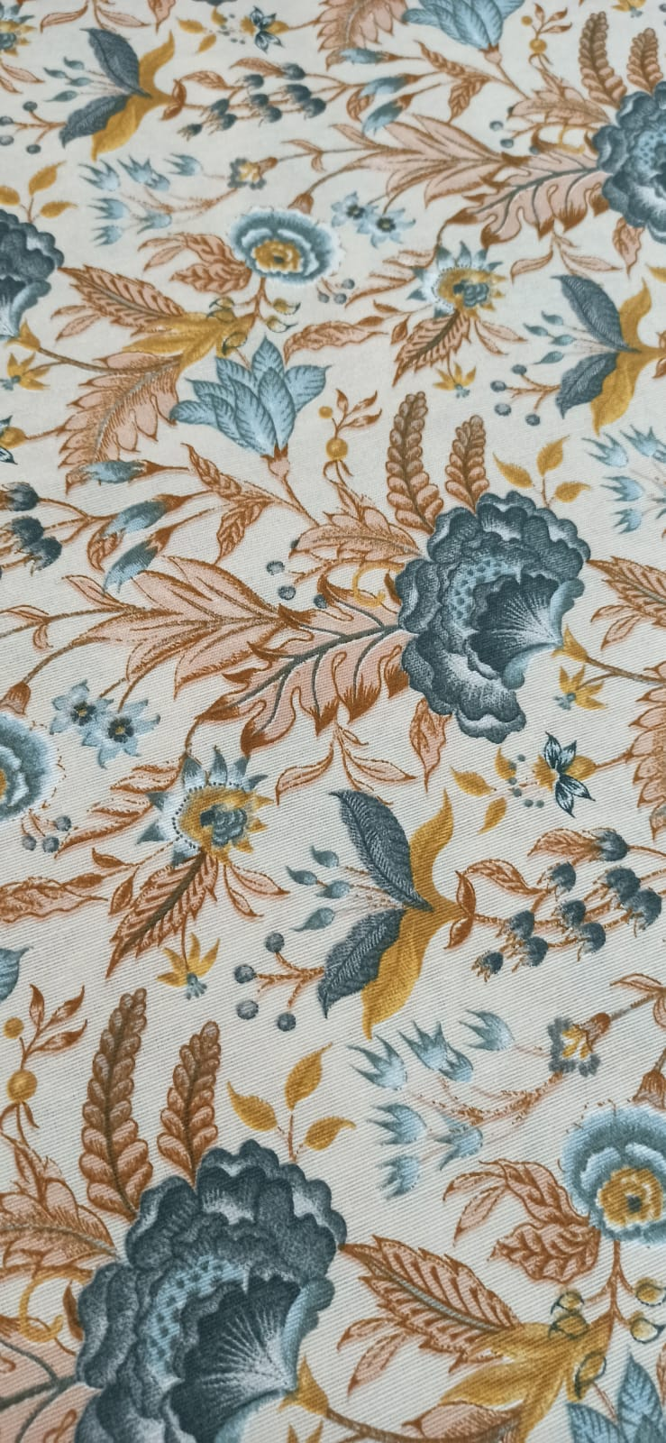 Loneta con flores jacobeas azules, ocres y terracota sobre fondo crudo