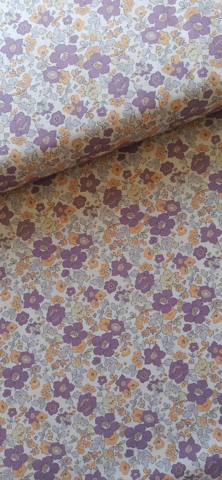 Algodón percal floral lila extendido con un pliegue